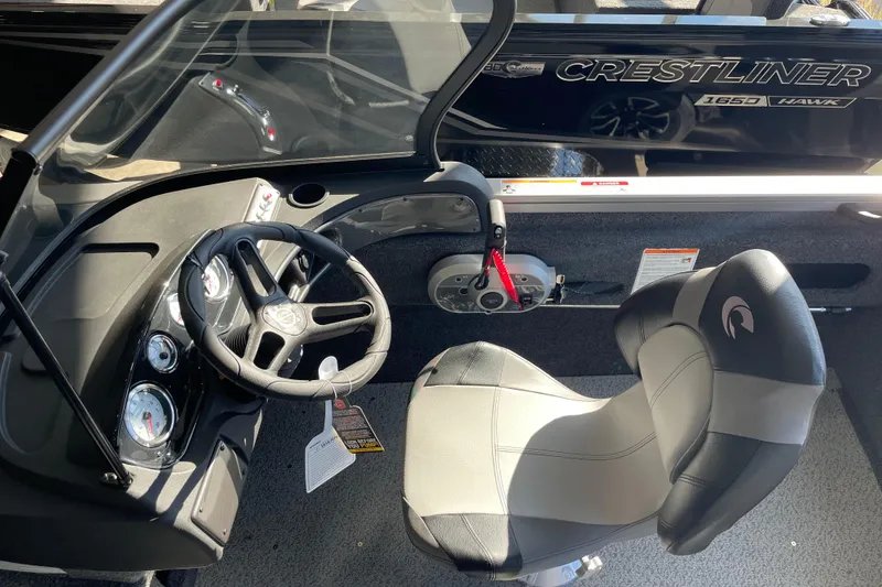 Slide: The Image of 2026 Crestliner 1650 Hawk boat interior with steering wheel and seat. - 11