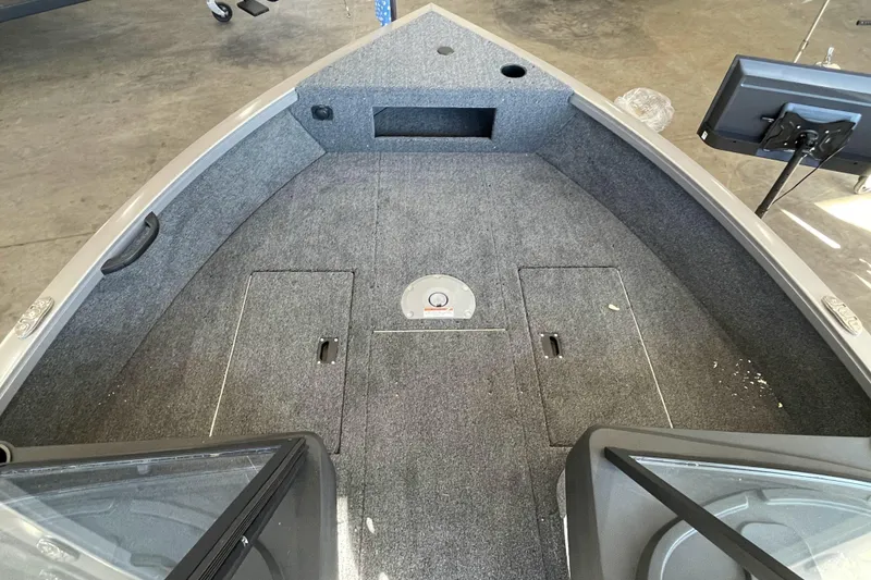 Slide: The Image of 2026 Crestliner 1650 Hawk boat interior with carpeted deck and storage compartments. - 15