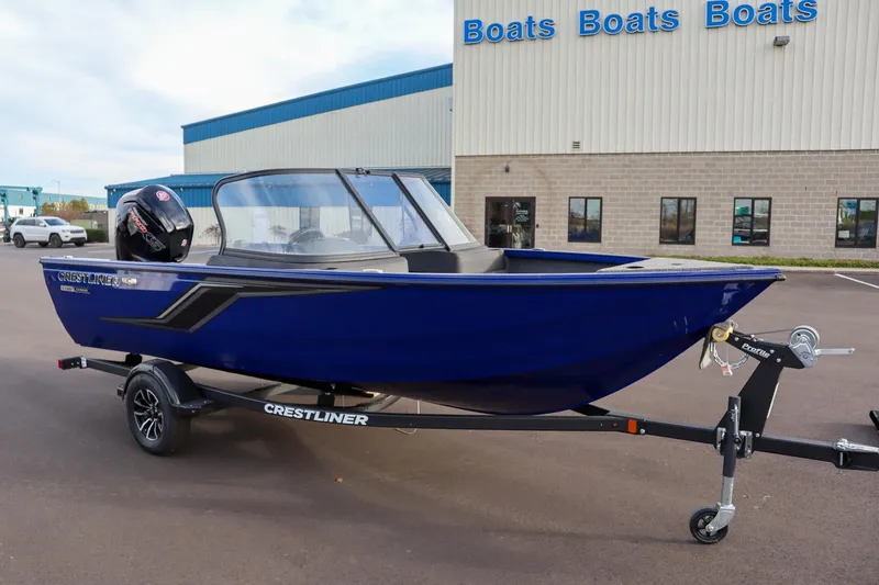Slide: The Image of 2026 Crestliner 1750 Hawk boat on trailer, parked outside a dealership. - 3