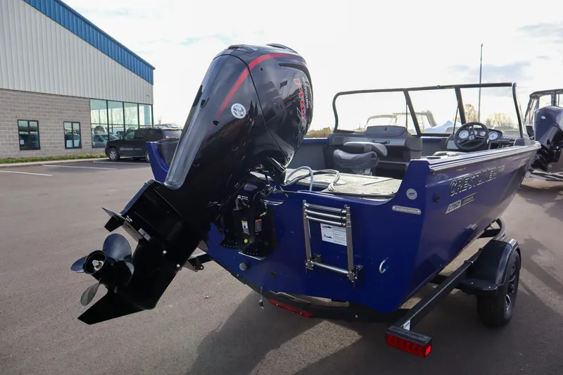 Slide: The Image of 2026 Crestliner 1750 Hawk boat with powerful outboard motor in a parking lot. - 5