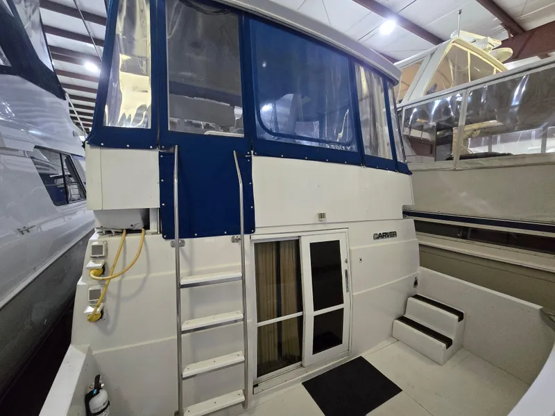 Slide: The Image of 1994 Carver 390 yacht in storage, featuring blue canopy and ladder access. - 17