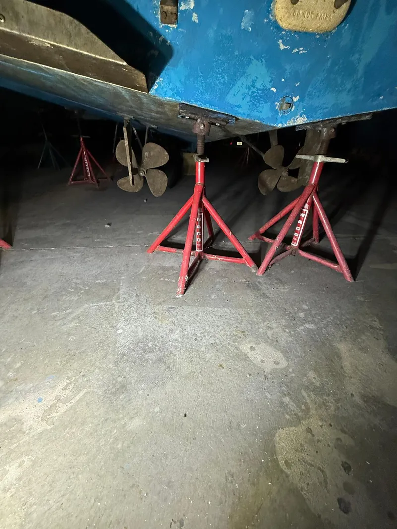 Slide: The Image of 1994 Carver 390 boat on red stands, showing propellers and hull underside. - 3