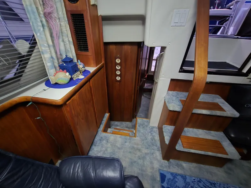Slide: The Image of 1994 Carver 390 interior with wooden cabinetry, carpeted stairs, and decorative accents. - 32