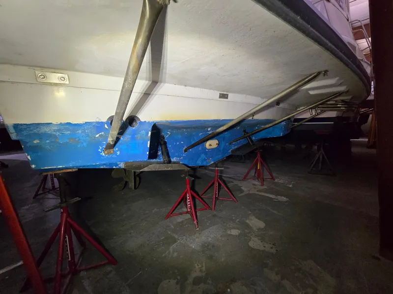 Slide: The Image of 1994 Carver 390 boat on stands, showing blue hull and metal supports. - 38