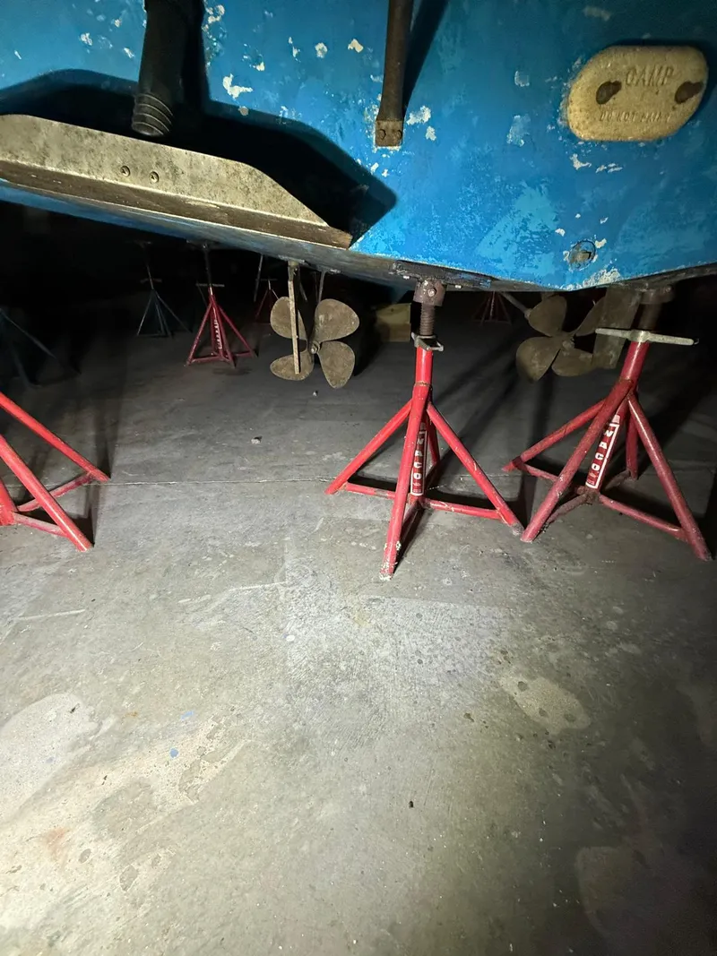 Slide: The Image of 1994 Carver 390 boat on red stands, showing dual propellers and blue hull. - 4