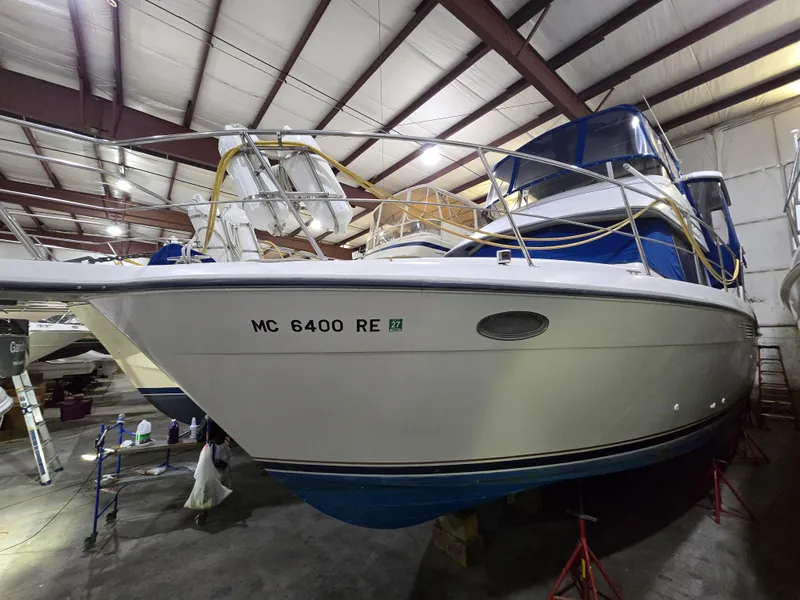The Image of 1994 Carver 390 boat stored indoors, showcasing hull and deck details. - 0