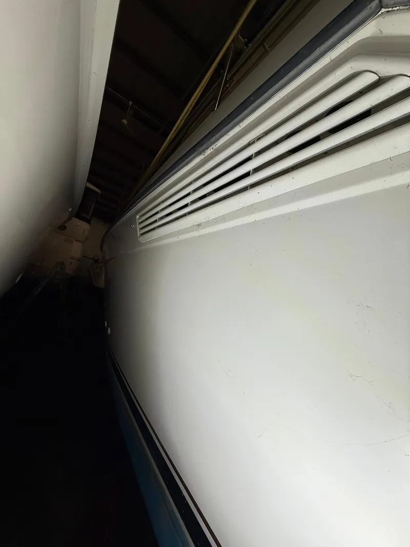 Slide: The Image of 1994 Carver 390 boat side view in storage, showcasing sleek design and ventilation details. - 12