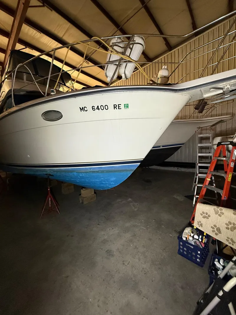 Slide: The Image of 1994 Carver 390 boat stored indoors, partially elevated, with visible registration number. - 14