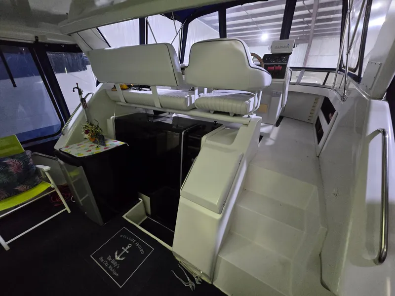 Slide: The Image of 1994 Carver 390 yacht interior with white seating and helm station. - 19