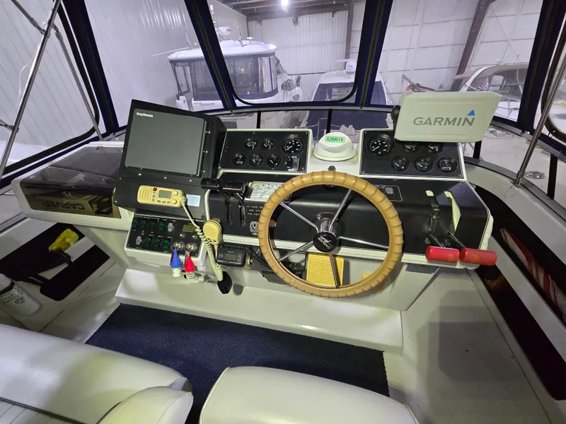 Slide: The Image of 1994 Carver 390 boat helm with Garmin navigation, steering wheel, and control panel. - 21