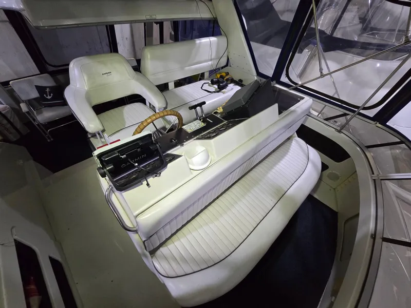 Slide: The Image of 1994 Carver 390 yacht cockpit with white seating, steering wheel, and control panel. - 22