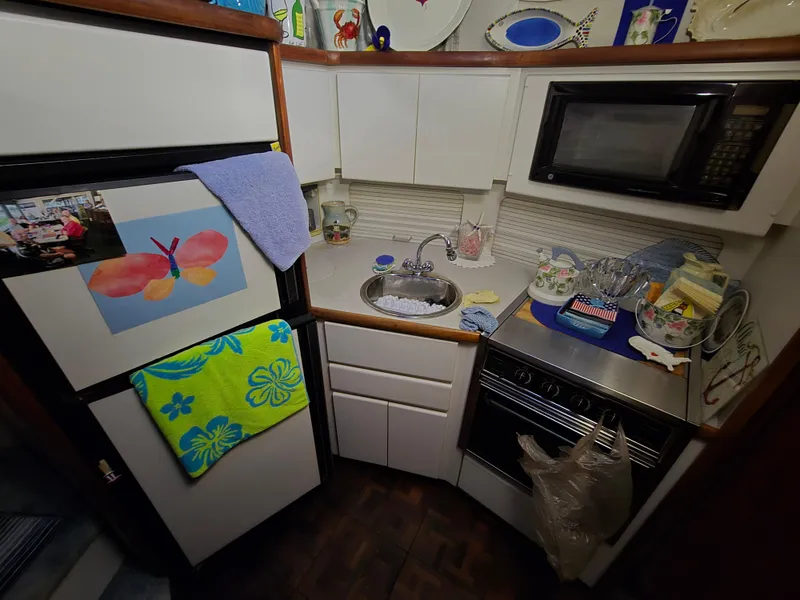 Slide: The Image of Compact kitchen in a 1994 Carver 390 boat with appliances and colorful decor. - 28