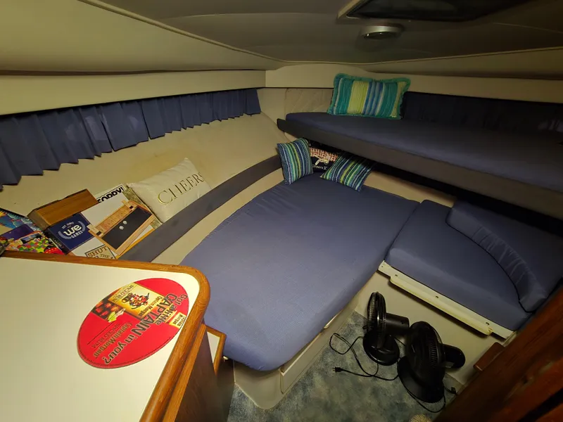 Slide: The Image of Cozy interior of 1994 Carver 390 boat with blue bedding and striped pillows. - 29