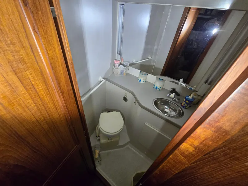 Slide: The Image of 1994 Carver 390 bathroom with wooden door, compact sink, and toilet. - 30