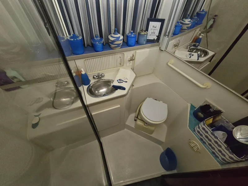 Slide: The Image of Bathroom interior of 1994 Carver 390 yacht with sink, toilet, and blue decor accents. - 36