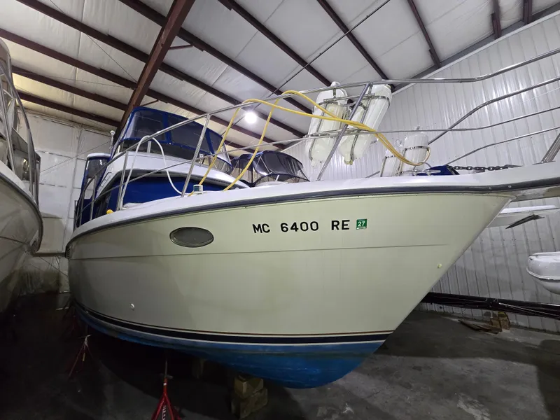 Slide: The Image of 1994 Carver 390 boat stored indoors, featuring a white hull and blue accents. - 41