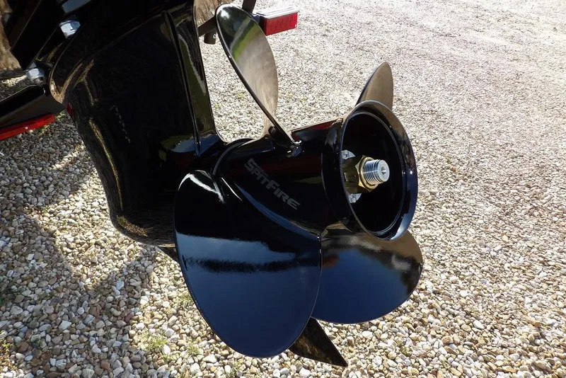 Slide: The Image of 2026 Lund 1775 Impact XS Sport boat propeller on gravel surface. - 10