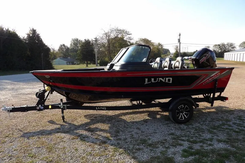 Slide: The Image of 2026 Lund 1775 Impact XS Sport boat on trailer, parked outdoors. - 14