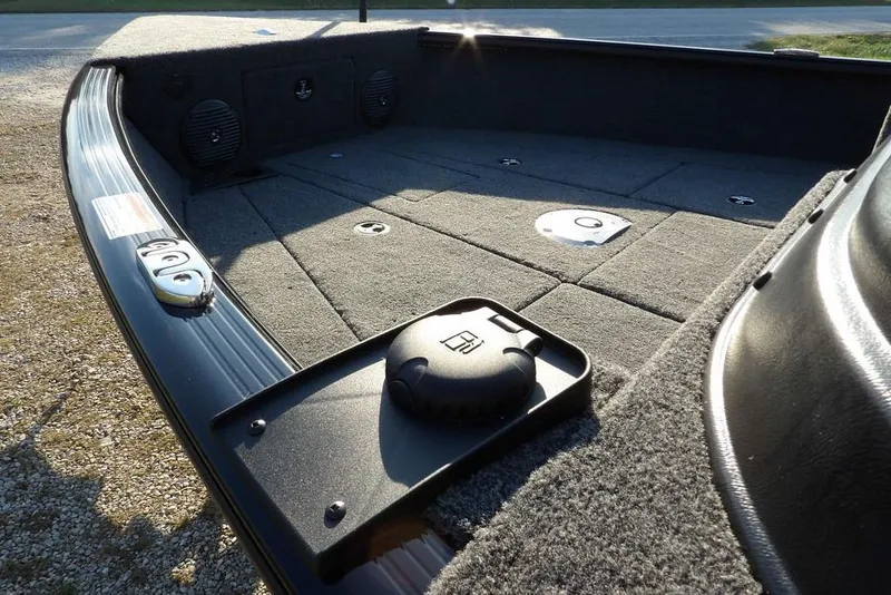 Slide: The Image of 2026 Lund 1775 Impact XS Sport boat deck with carpeted surface and storage compartments. - 16