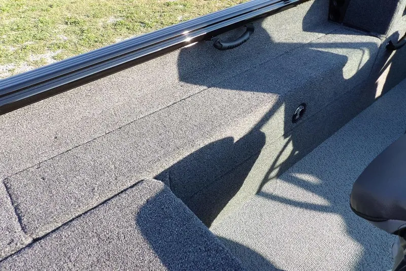 Slide: The Image of Interior view of 2026 Lund 1775 Impact XS Sport boat, featuring carpeted seating area. - 21