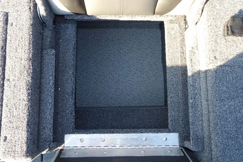 Slide: The Image of 2026 Lund 1775 Impact XS Sport boat storage compartment with carpeted interior. - 22