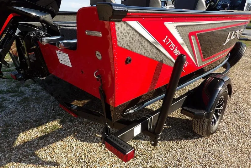 Slide: The Image of 2026 Lund 1775 Impact XS Sport boat, red and black design, on a trailer. - 3