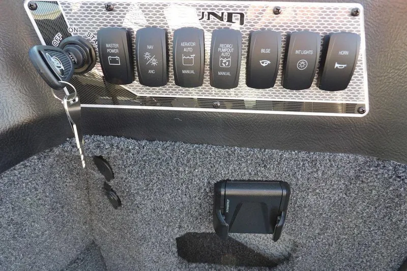Slide: The Image of Control panel of 2026 Lund 1775 Impact XS Sport boat with switches and key. - 31
