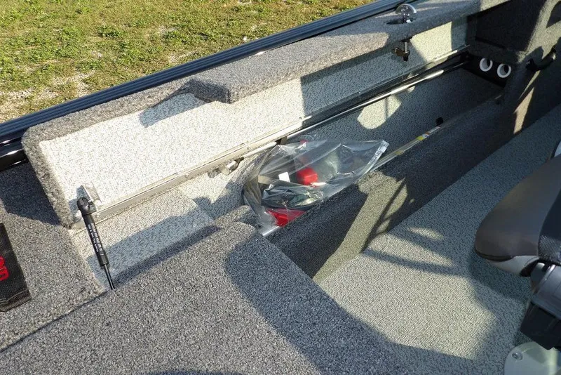 Slide: The Image of 2026 Lund 1775 Impact XS Sport boat interior storage compartment with fishing gear. - 33
