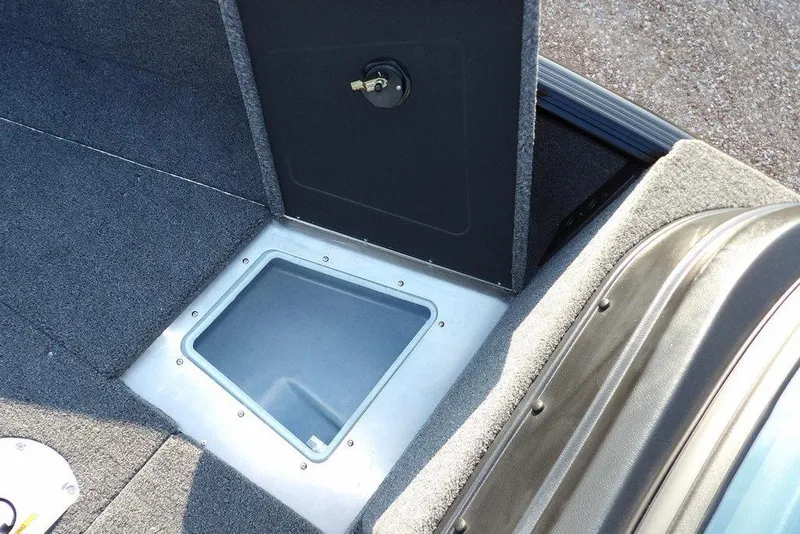 Slide: The Image of 2026 Lund 1775 Impact XS Sport boat interior with storage compartment and carpeted flooring. - 48