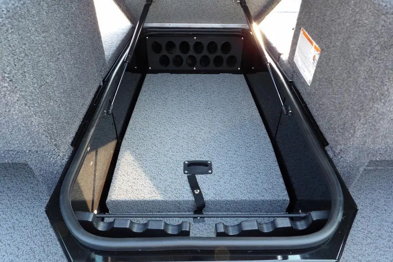 Slide: The Image of 2026 Lund 1775 Impact XS Sport boat storage compartment with rod holders and carpeted interior. - 50