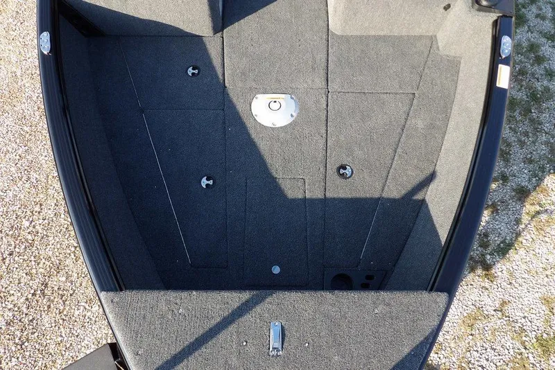 Slide: The Image of 2026 Lund 1775 Impact XS Sport boat interior with carpeted deck and storage compartments. - 54