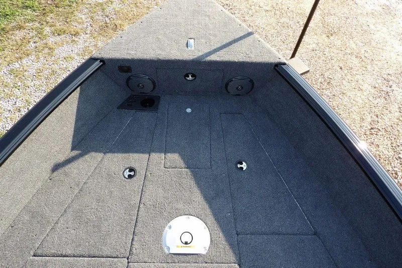 Slide: The Image of 2026 Lund 1775 Impact XS Sport boat interior with carpeted deck and storage compartments. - 56