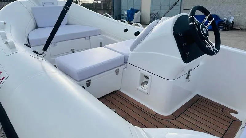 Slide: The Image of 2024 Aqvaboats LUXRIB 14 interior with white seating and wooden flooring. - 7