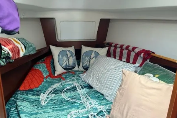 Slide: The Image of Cozy cabin interior of 2003 Beneteau 331 sailboat with nautical-themed bedding and pillows. - 10