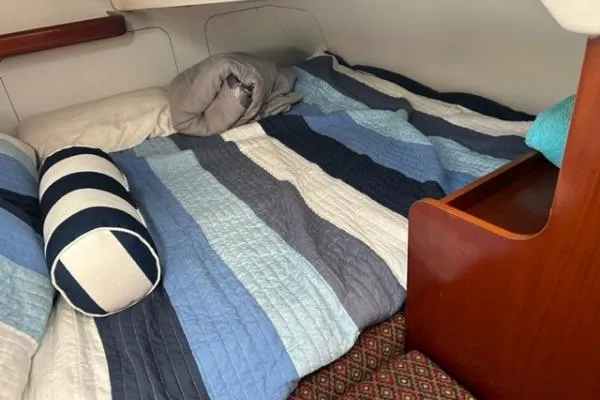 Slide: The Image of Cozy cabin bed in 2003 Beneteau 331 sailboat with striped bedding. - 11