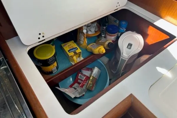 Slide: The Image of Storage compartment in a 2003 Beneteau 331 sailboat with various kitchen items. - 17
