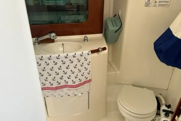 Slide: The Image of 2003 Beneteau 331 yacht bathroom with sink, toilet, and anchor-patterned towel. - 18
