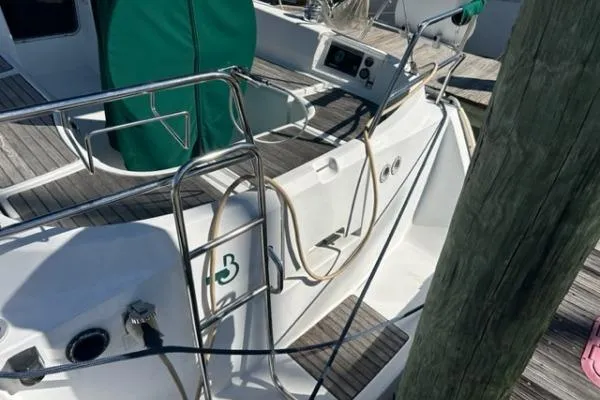 Slide: The Image of 2003 Beneteau 331 sailboat deck with green cover and docked at marina. - 4