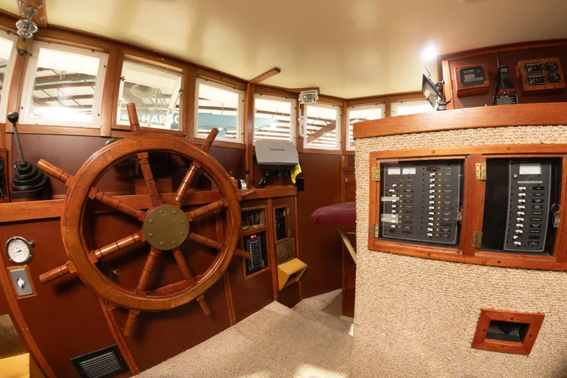 Slide: The Image of Interior helm of 1993 Custom Steel Trawler with wooden wheel and control panels. - 14