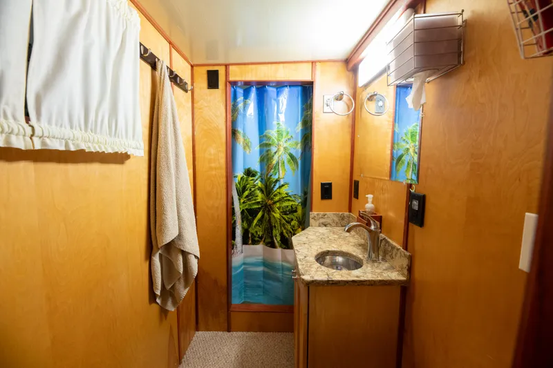Slide: The Image of 1993 Custom Steel Trawler bathroom with tropical shower curtain, wooden walls, and granite countertop. - 21