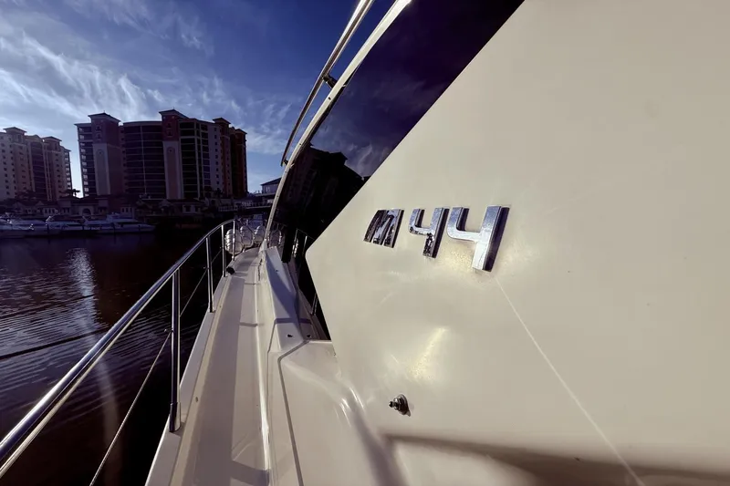 Slide: The Image of 2016 Cranchi M 44 HT yacht docked near waterfront buildings under a clear sky. - 16