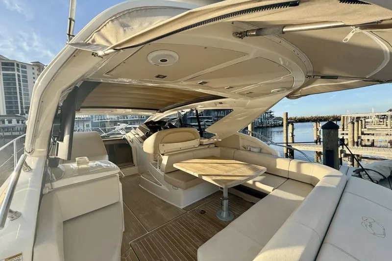 Slide: The Image of Luxurious 2016 Cranchi M 44 HT yacht interior with elegant seating and table, docked at marina. - 25