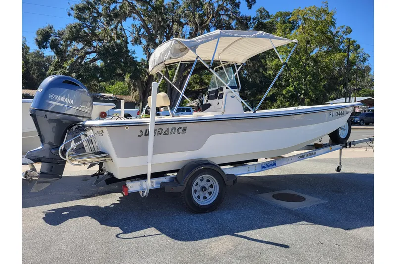 The Image of 2018 Sundance B18CCR boat on trailer with Yamaha outboard motor, parked outdoors. - 0