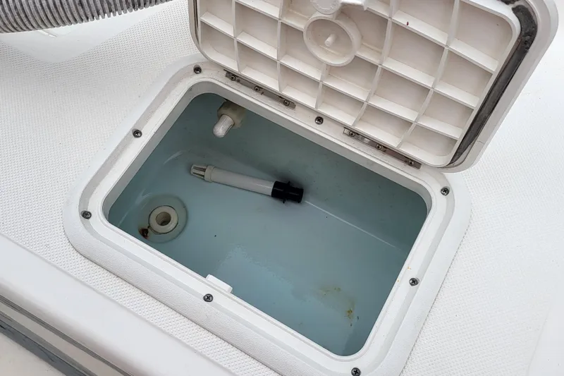 Slide: The Image of Open storage compartment on 2018 Sundance B18CCR boat, showing interior details. - 10