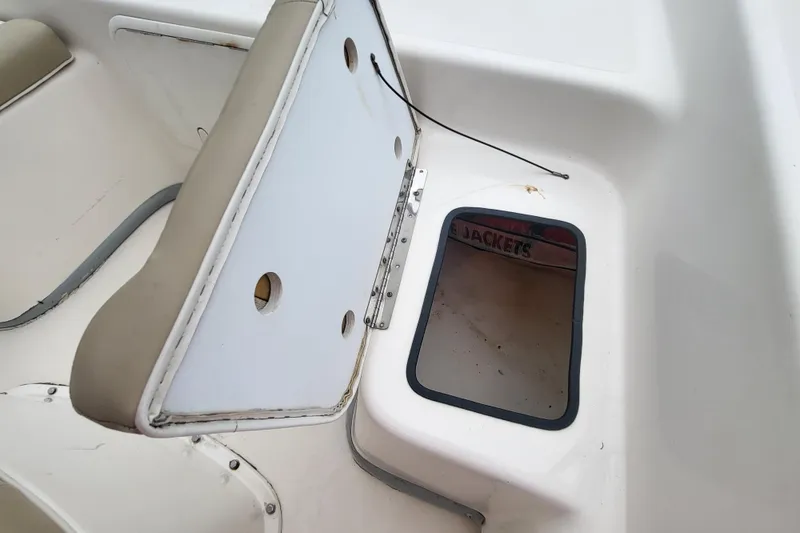 Slide: The Image of 2018 Sundance B18CCR boat storage compartment with open hatch and visible life jackets. - 3