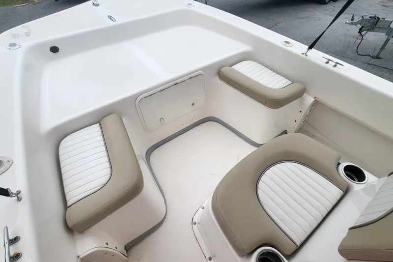 Slide: The Image of 2018 Sundance B18CCR boat interior with cushioned seating and cup holders. - 4