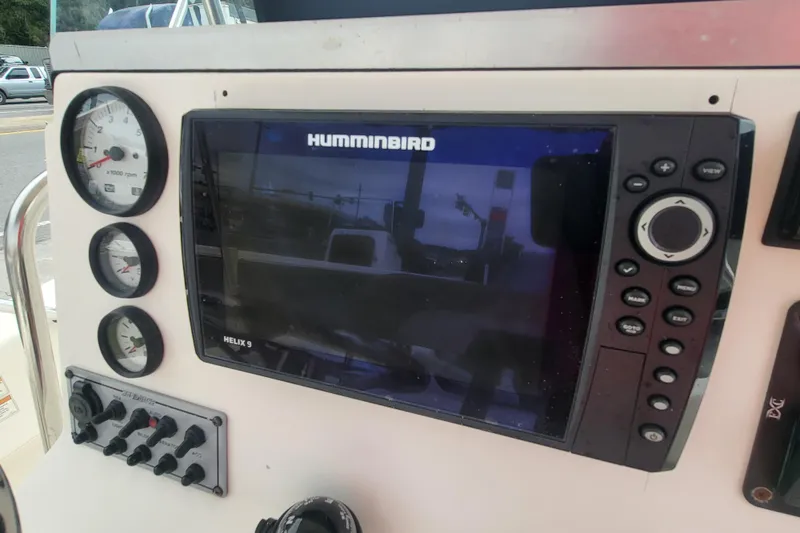 Slide: The Image of 2018 Sundance B18CCR boat dashboard with Humminbird Helix 9 display and gauges. - 8