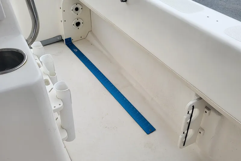 Slide: The Image of Interior of 2018 Sundance B18CCR boat with rod holders and blue measuring strip. - 9