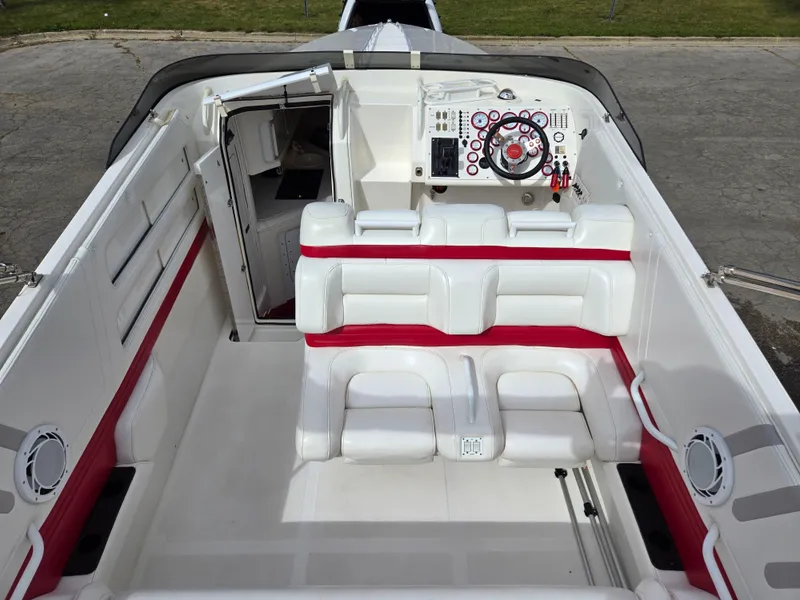 Slide: The Image of 1995 Fountain 38 Sport Cruiser interior with white and red seating, sleek dashboard, and open cabin door. - 19