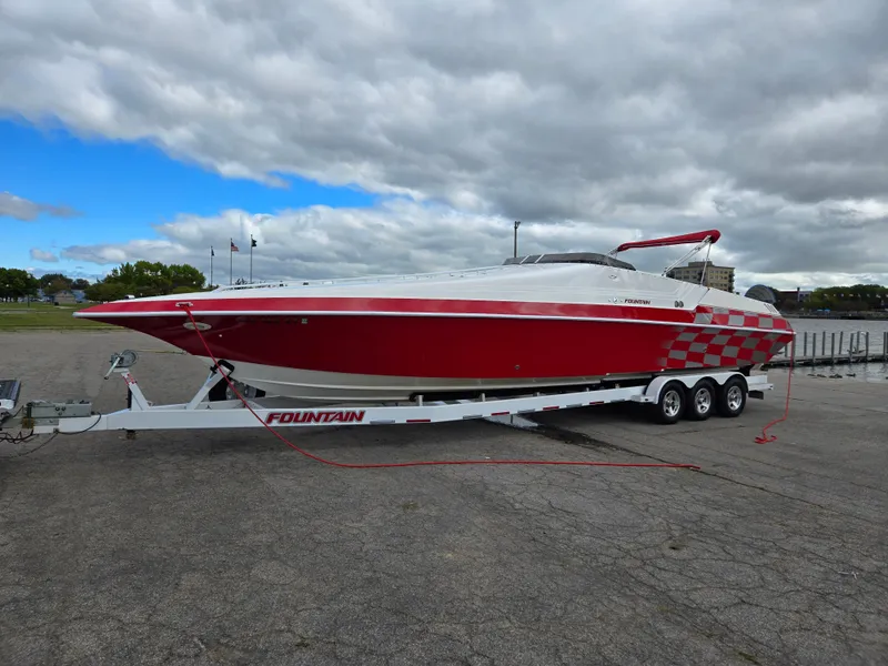 Slide: The Image of Red and white 1995 Fountain 38 Sport Cruiser on a trailer under cloudy skies. - 2